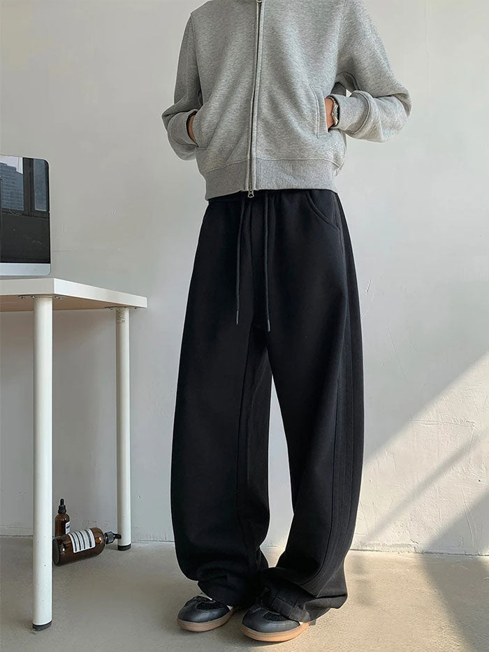 Casual black wide-leg sweatpants styled with grey zip hoodie, front view.