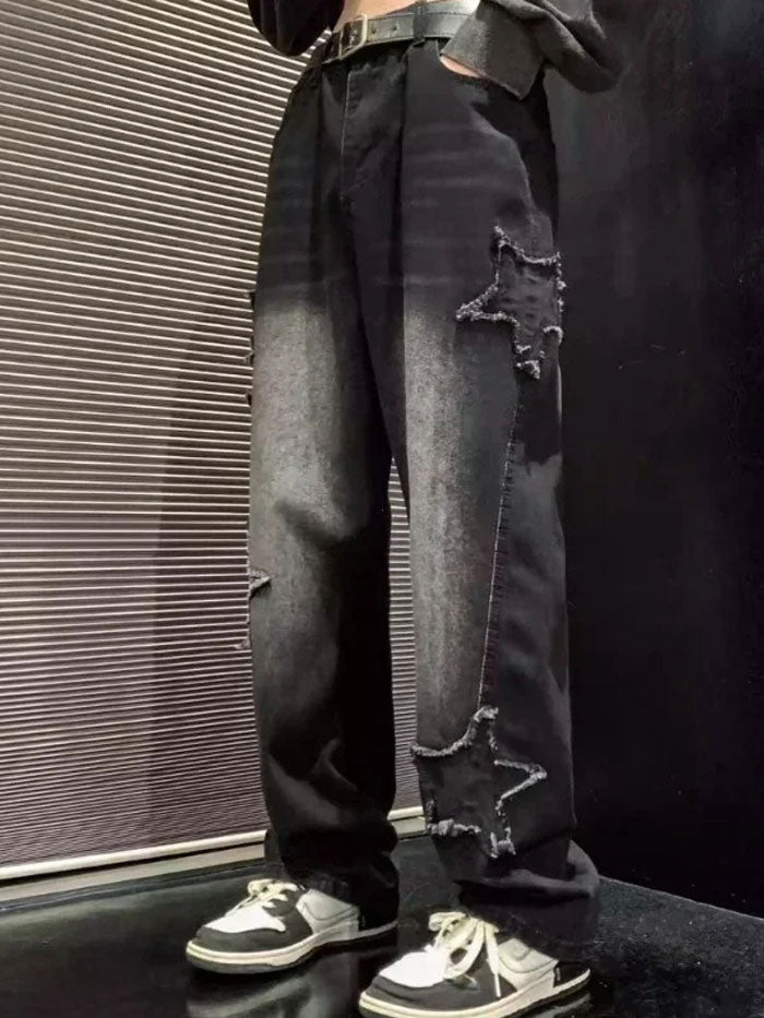 Oversized black denim jeans with multiple star-shaped distressed patches, styled with black and white sneakers.