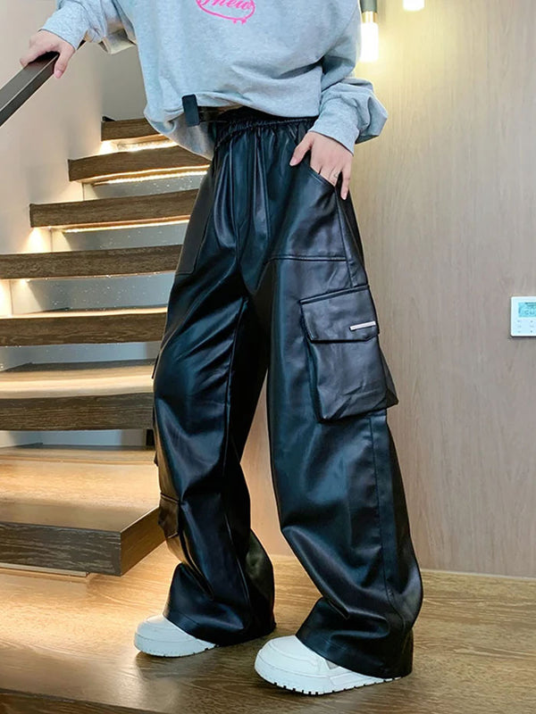 Side view of black faux leather pants with flap cargo pockets.