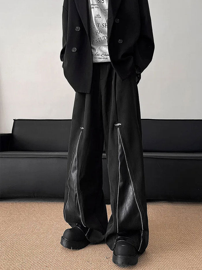 Model sitting wearing black urban-style zipper pants with bold streetwear vibes.