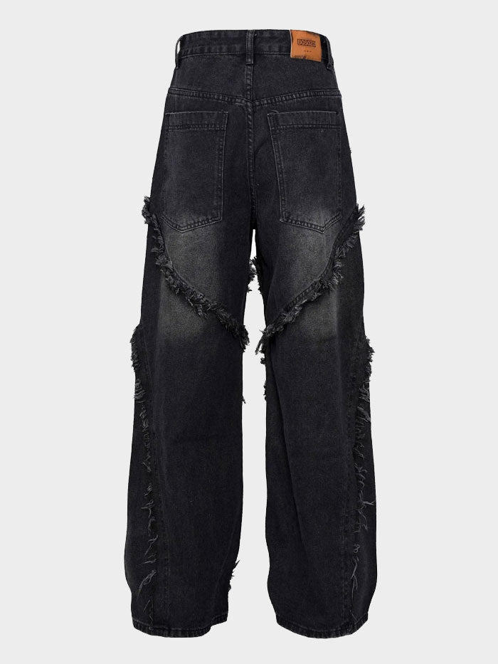 Back view of black denim jeans with wavy fringe accents and rear pockets