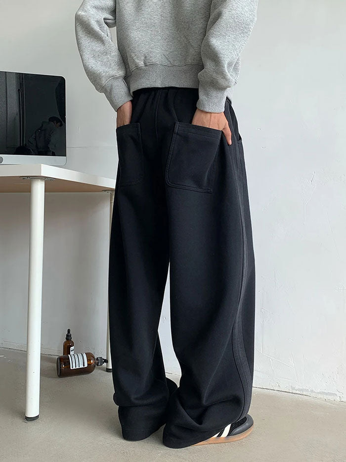 Black oversized sweatpants with large rear patch pockets, back view.