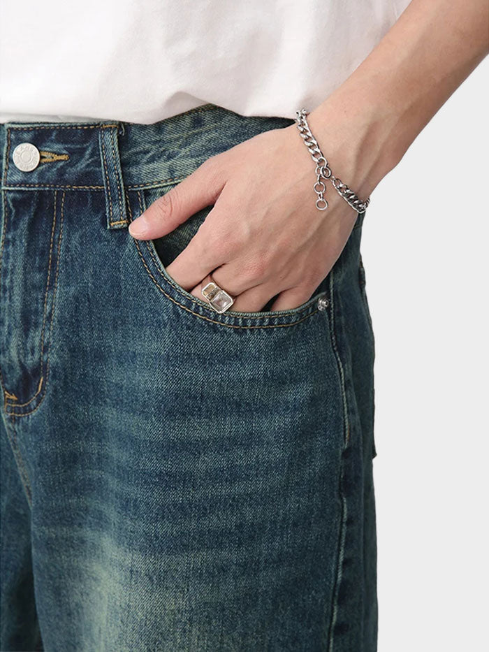 Close-up of pocket stitching and vintage wash on mid-blue denim shorts.