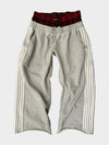 Grey jogger-style track pants featuring white side stripes and red plaid waistband design by Concrete Mans.