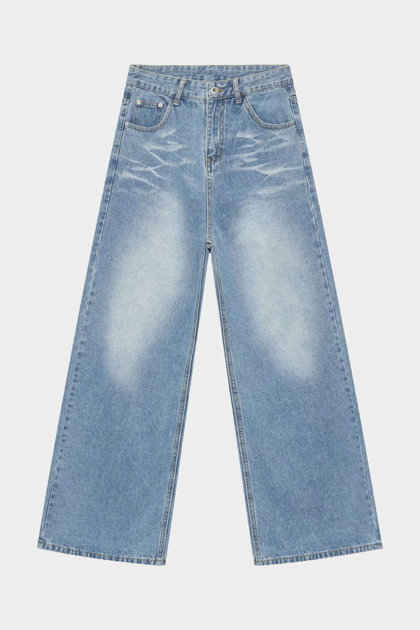 Flat lay of wide-leg light wash jeans with distinctive faded wash and relaxed cut