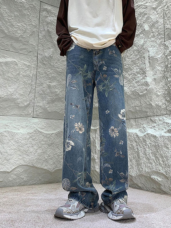 Close-up of embroidered floral design on blue denim jeans.