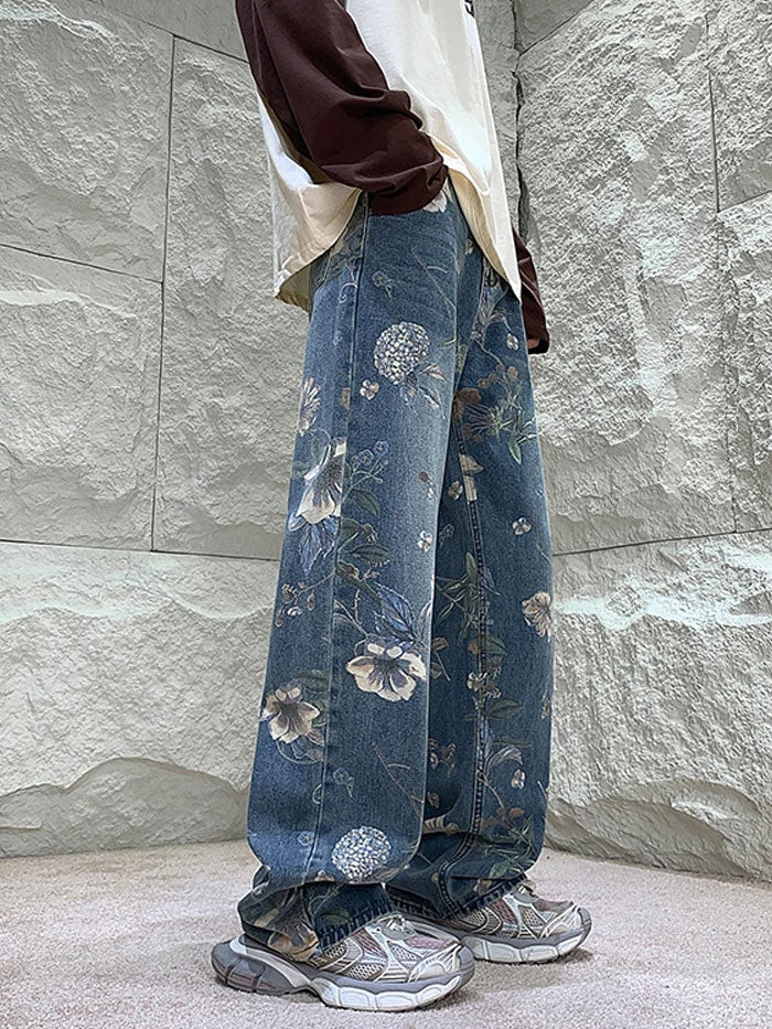 Back pocket of denim jeans with intricate pink and white floral embroidery.