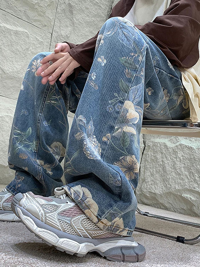 Waistband and upper section of floral embroidered jeans with button closure.