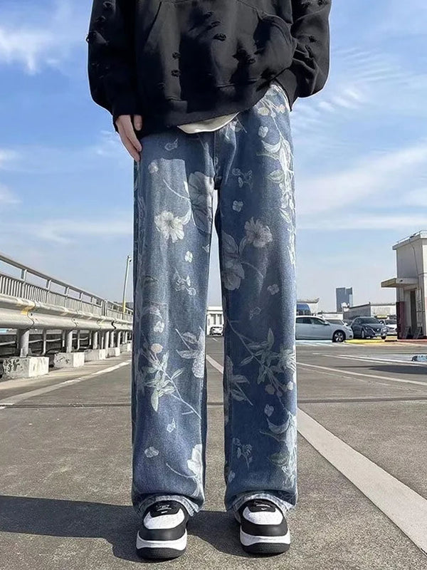 Close-up of floral denim jeans styled with black hoodie and sneakers in an urban streetwear look.