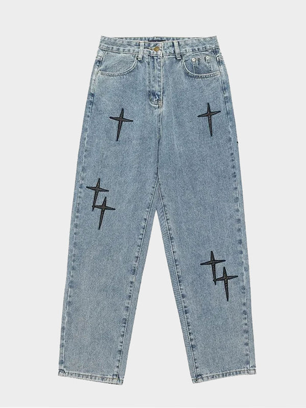 Front-facing view of light-wash baggy jeans featuring bold black cross patches.