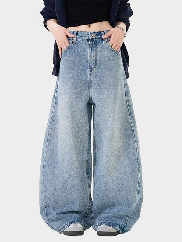 Front view of a woman wearing high-waisted, wide-leg baggy denim jeans styled with a black crop top.