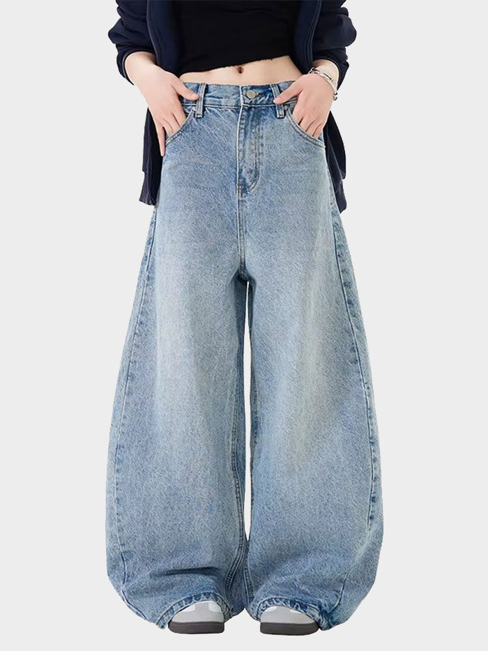 Front view of a woman wearing high-waisted, wide-leg baggy denim jeans styled with a black crop top.