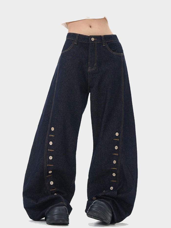 Model wearing high-rise balloon jeans in dark wash, styled with side button accents.