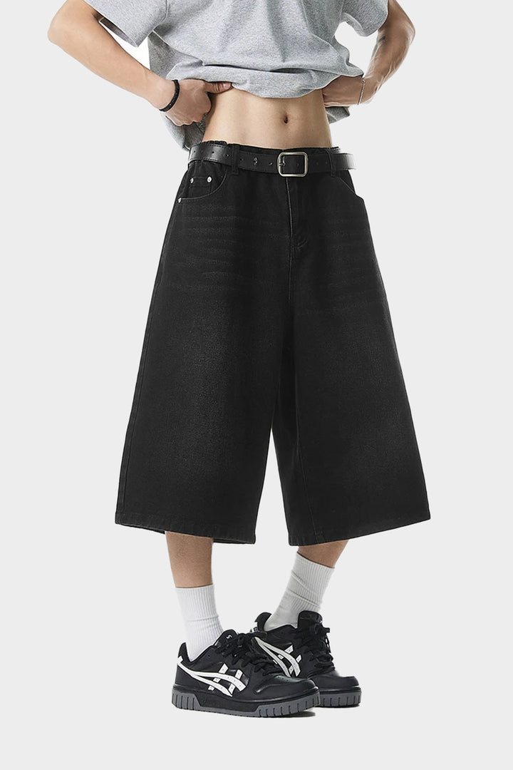 Front view of black wide-leg denim shorts styled with grey tee and sneakers