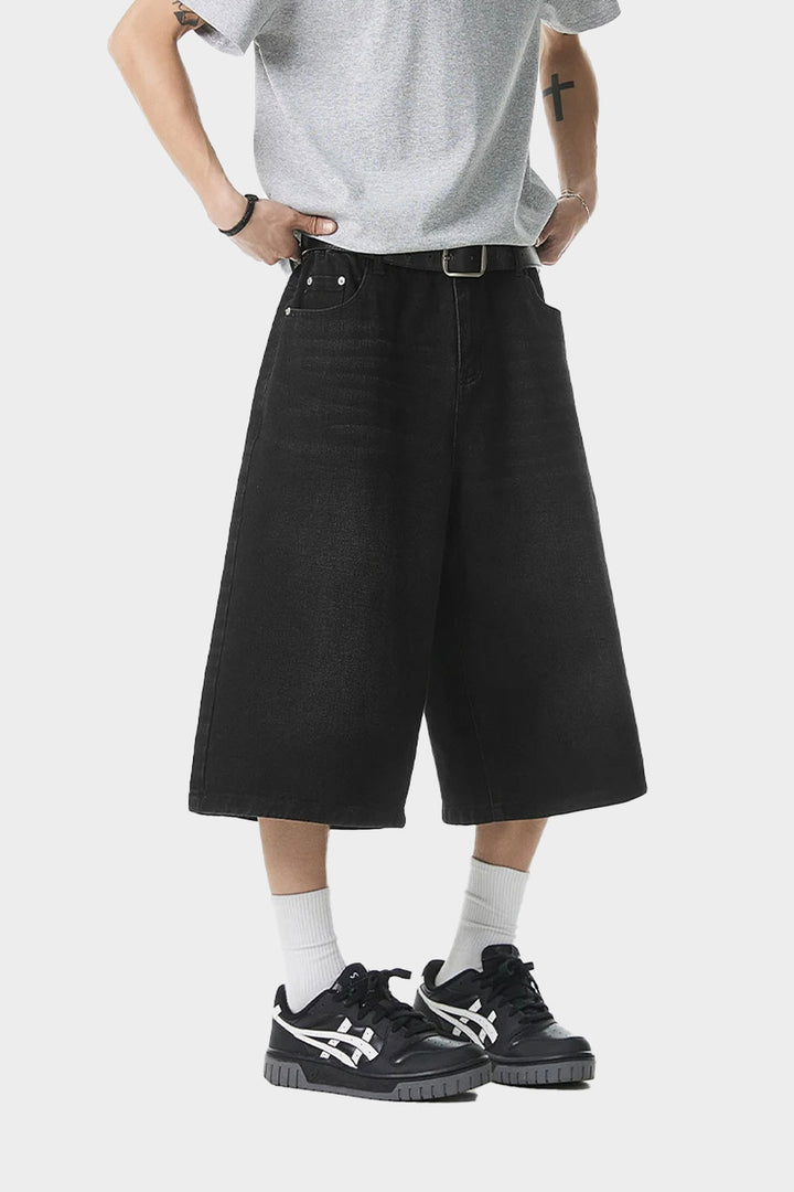 Side view of black oversized denim shorts showing wide-leg cut