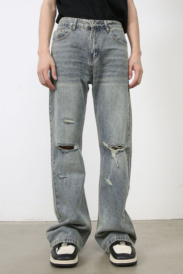 Front view of light-wash distressed wide-leg jeans styled with a black tee and sneakers