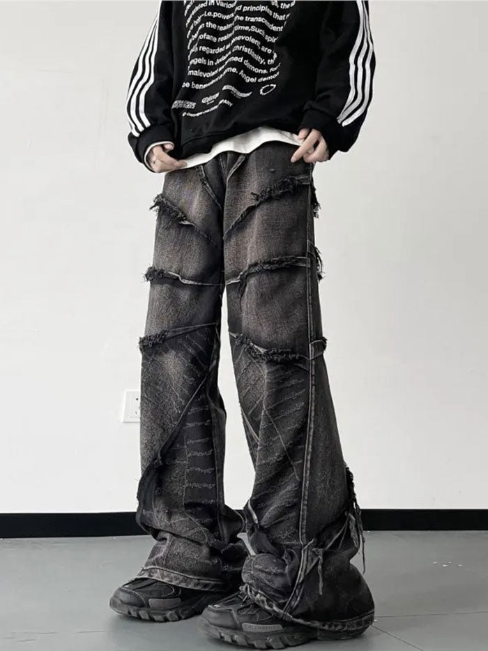 Man wearing vintage patchwork baggy jeans sitting on curb in urban setting.