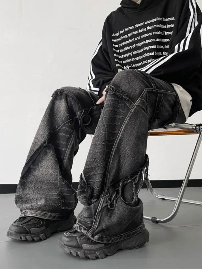 Full front view of man modeling oversized vintage denim jeans with distressed details.