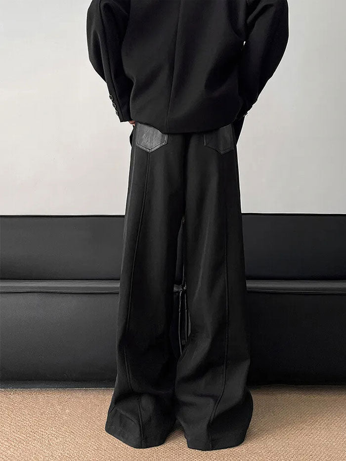 Side view of wide-leg black pants showcasing a leather back pocket.