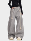 Oversized gray sweatpants with thick rope drawstrings and elastic waist, front view.