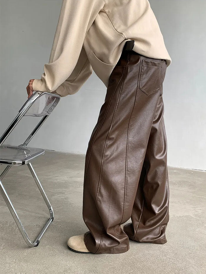 Men's relaxed brown leather trousers styled with neutral tones.