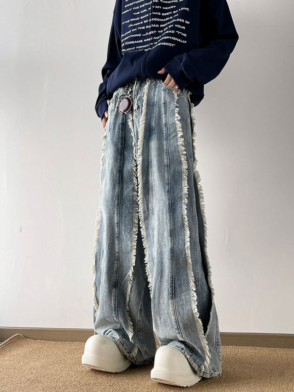  Side profile of oversized streetwear jeans featuring deep side slits and raw hems, in light blue wash.