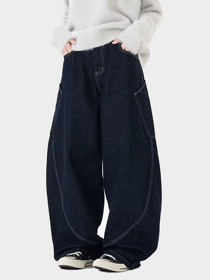 Side angle of women wide-leg jeans in dark denim with oversized silhouette and curved panel seams.