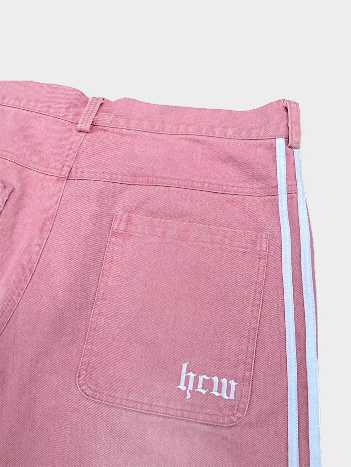 Back view of pink jeans highlighting rear pocket with white "hcw" logo and white side stripes.