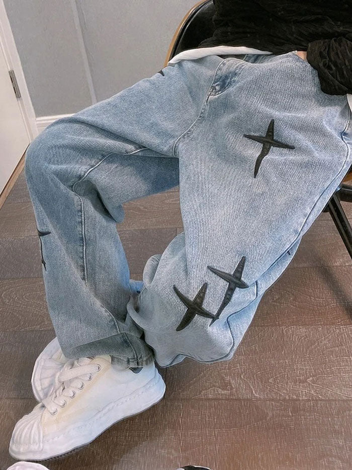 Relaxed fit denim jeans styled for streetwear with cross patch accents.