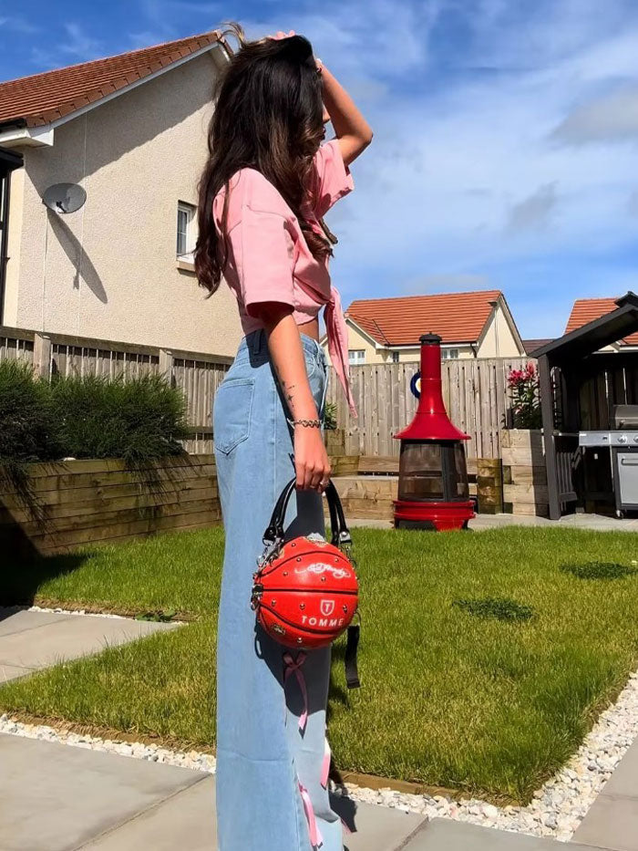 Woman wearing jeans with a pink bow detail, showcasing trendy casual fashion.
