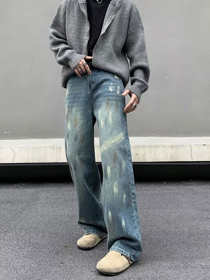 Trendy baggy jeans styled with grey cardigan and beige shoes on street.