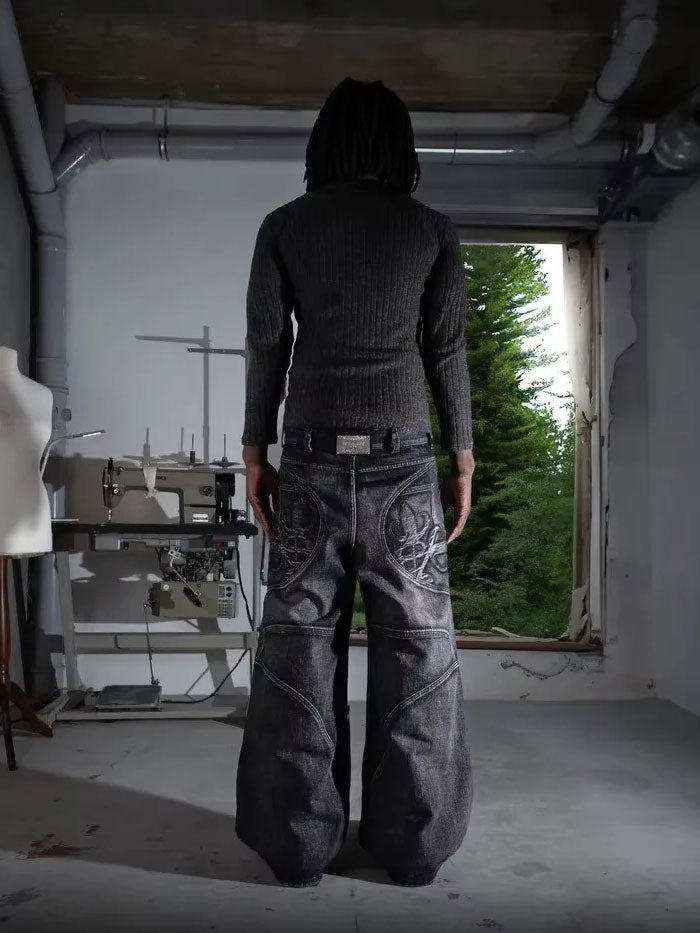 Front view of black wide-leg denim jeans laid flat, showcasing exaggerated wide-leg cut and distressed faded wash.