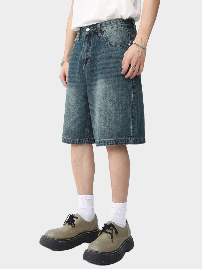Side view of relaxed fit denim shorts in a mid-length cut with vintage fade.