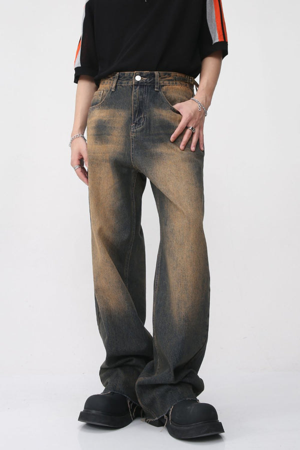 Front view of vintage-washed brown wide-leg jeans with faded finish and raw hems.