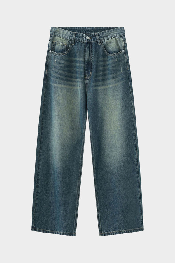 Flat lay of washed blue wide-leg jeans showcasing whisker detailing and wide cut.