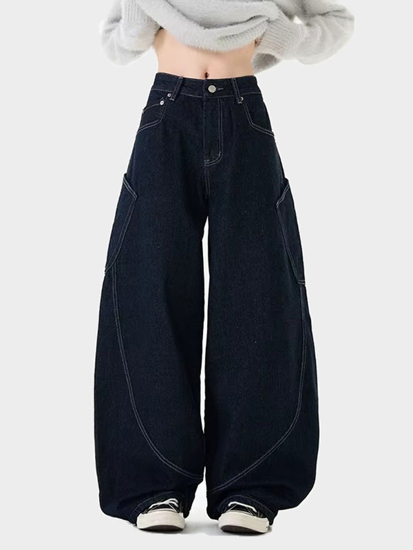 Model wearing women dark denim wide-leg jeans with exaggerated curved seam design and relaxed baggy fit.