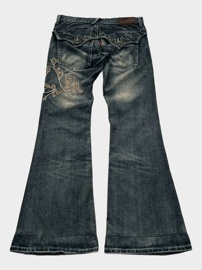 Back view of embroidered flared jeans featuring decorative stitching on pocket.