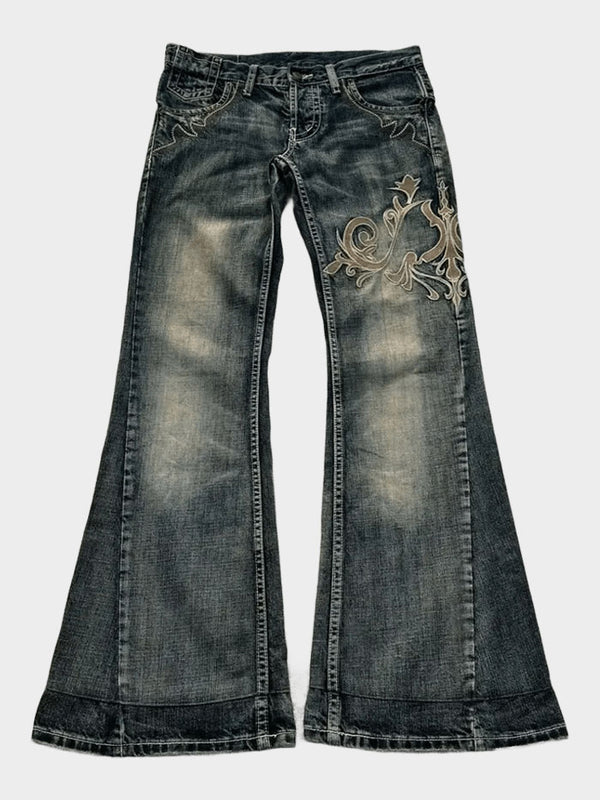 Front view of women's flared denim jeans with tan embroidery on the thigh
